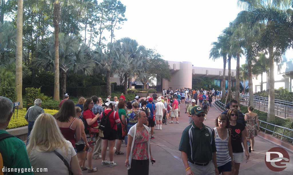 The line for Epcot30 merchandise stretches past Spaceship Earth