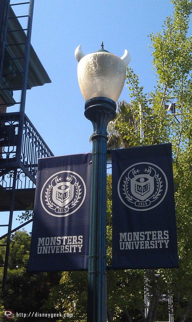 A couple banners for Monsters University notice the light post