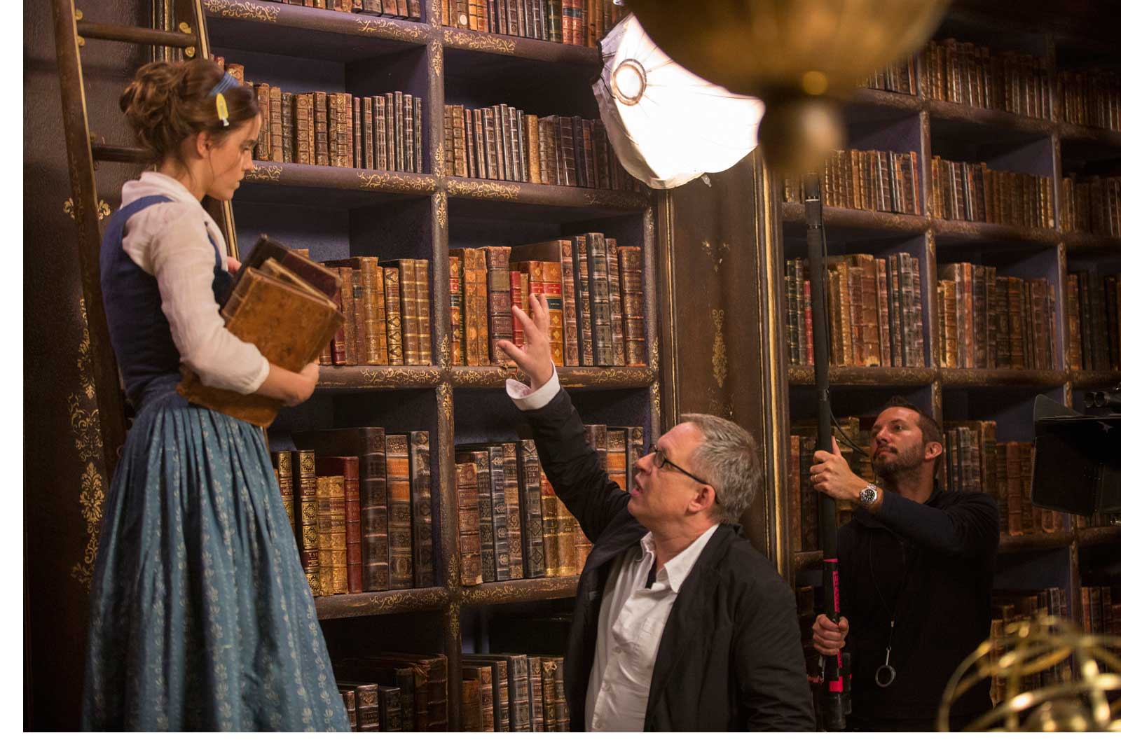 Director/co-screenwriter Bill Condon on set with Belle (Emma Watson) in Disney's BEAUTY AND THE BEAST, a live-action adaptation of the studio's animated classic. The story and characters audiences know and love are brought to life in this stunning cinematic event...a celebration of one of the most beloved stories ever told.