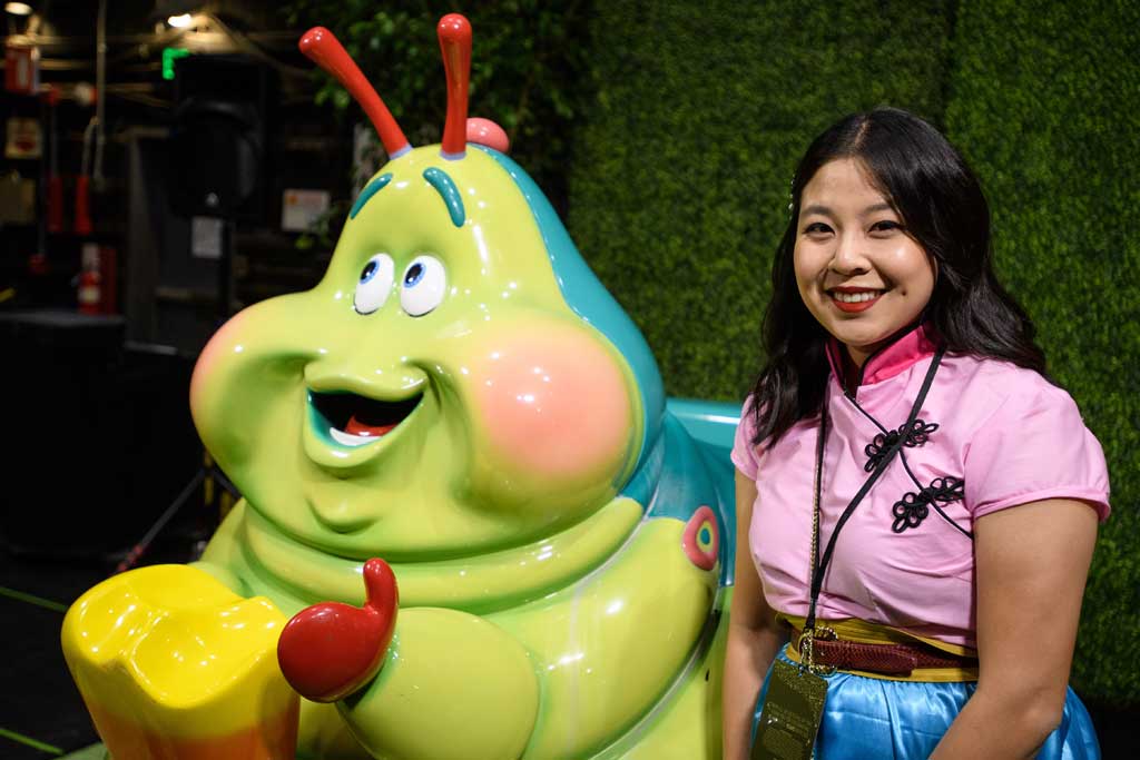 A guest poses with Heimlich’s Chew Chew Train on display from the Walt Disney Archives at D23’s 10-Year FAN-niversary Celebration at the Walt Disney Studios, March 10, 2019.