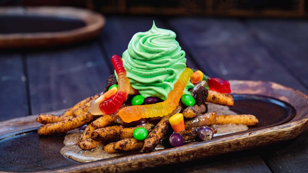 At Award Wieners at Disney California Adventure Park, guests will find these Oogie Boogie-inspired funnel cake fries dusted in crushed chocolate cream cookies, topped with cream cheese sauce, chocolate cream cookie pieces, gummy candies, chocolate coated candies and whipped cream. (David Nguyen/Disneyland Resort)