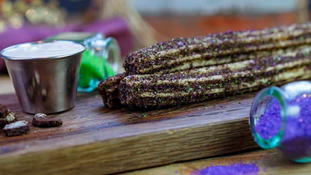 At the churro carts in Town Square and near the Sleeping Beauty Castle at Disneyland Park, guests will find this Maleficent-inspired churro covered with chocolate cookie crumbles, blended with colored sugar. (David Nguyen/Disneyland Resort)