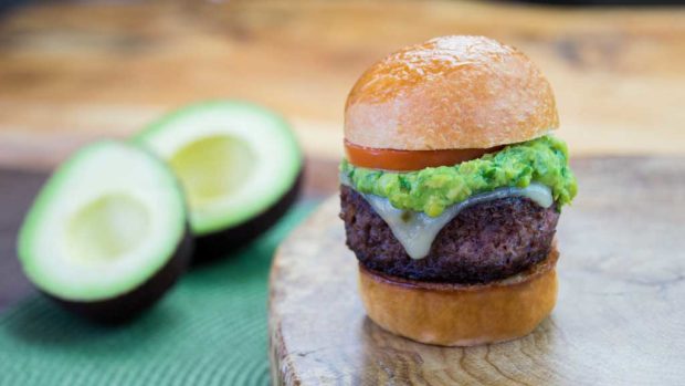 Petite Impossible™ burger with guac and pepper jack cheese topped with melted pepper jack cheese, fresh guacamole and tomato, on a toasted mini brioche bun.