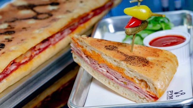 Experiment No. EE10: Pym-ini, a panini on toasted focaccia with salami, rosemary ham, provolone, sun-dried tomato mayonnaise and arugula with marinara dipping sauce, which can be served by the slice or as a long, multi-portion sandwich. (David Nguyen/Disneyland Resort)