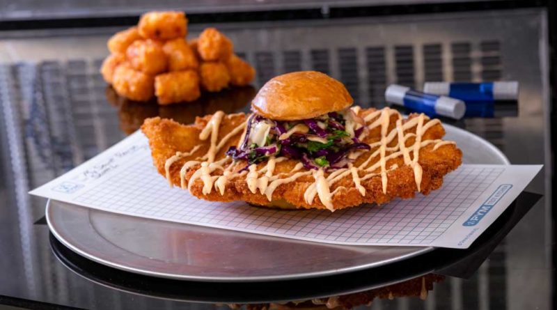 Experiment No. EE90: Not So Little Chicken Sandwich features a fried chicken breast with teriyaki and red chili sauces, pickled cabbage slaw and crispy potato tots. (David Nguyen/Disneyland Resort)