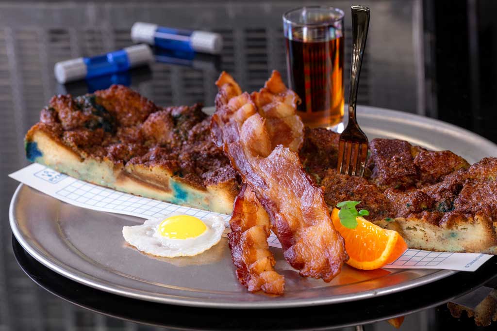 Ever-Expanding Cinna-Pym Toast made with baked Pym particle bread and egg custard with cinnamon-sugar topping, a fried egg, smoked bacon, and maple syrup. (David Nguyen/Disneyland Resort)