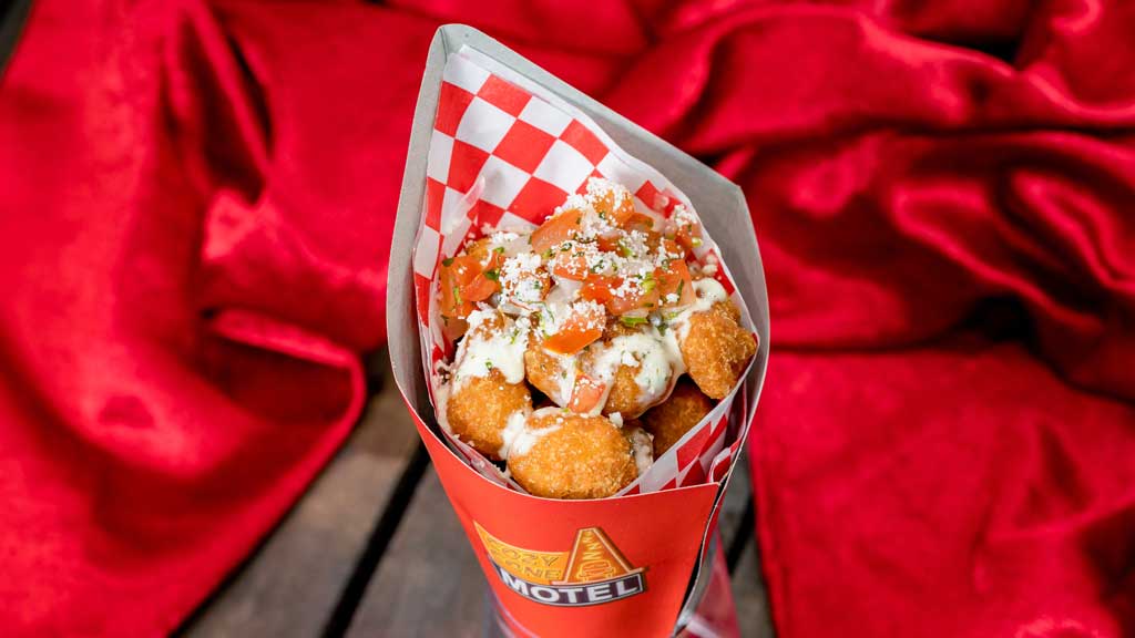 Esquite Corn Fritters (Cozy Cone at Disney California Adventure Park in Anaheim, Calif.) - Fried corn fritters tossed in chile-lime seasoning and topped with cilantro-lime dressing, cotija cheese and pico de gallo.