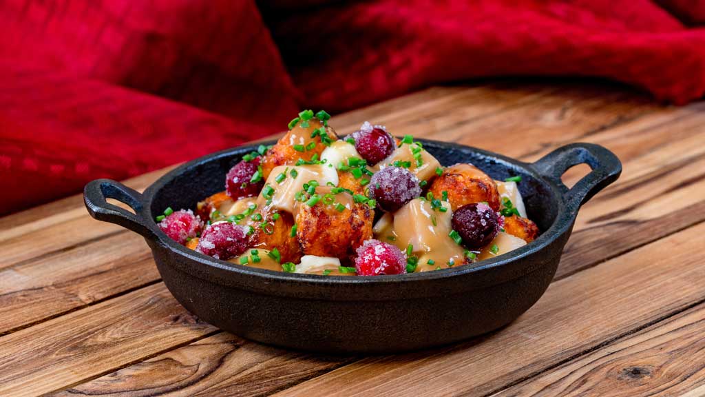 Turkey Poutine (Merry Mashups marketplace at Disney California Adventure Park in Anaheim, Calif.) - Layers of roasted turkey, sweet potato bites, cheese curds and gravy, topped with frosted cranberries.