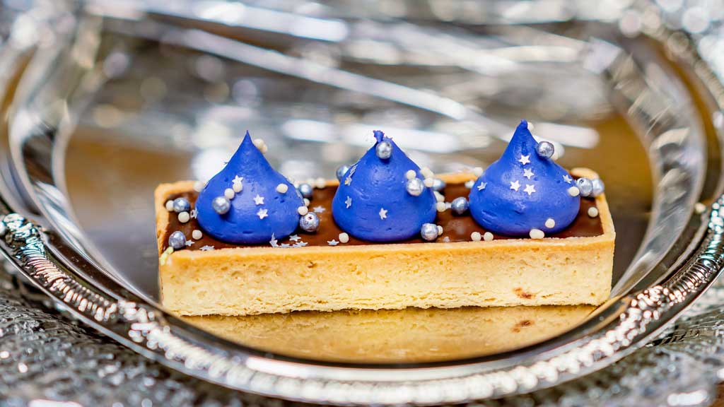 Mr. Banks Shortbread Tart (Jolly Holiday Bakery Café at Disneyland Park in Anaheim, Calif.) - caramel and chocolate ganache in a shortbread tart, purple-colored white chocolate mousse, sea salt, edible silver stars and silver crunch pearls.