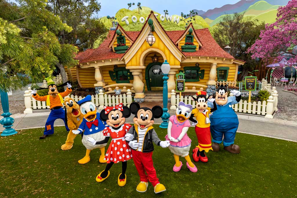  Mickey Mouse, Minnie Mouse and their pals pose in the newly reimagined Mickey's Toontown at Disneyland Park in Anaheim, Calif. For the first time at any Disney park, Pete also makes appearances as he causes mischief around the neighborhood. Mickey Mouse sports a new outfit specifically for when he is greeting guests outside of his home. At this animated neighborhood, families can explore, play, discover and unwind together while enjoying new interactive experiences, returning familiar favorites and the new attraction Mickey & Minnie’s Runaway Railway. (Christian Thompson/Disneyland Resort) 
