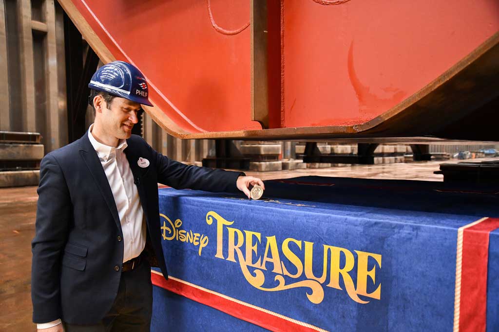 Philip Gennotte, portfolio project management executive, Walt Disney Imagineering Germany, took part in the keel laying ceremony for the Disney Treasure at Meyer Werft shipyard in Papenburg, Germany. During the ceremony, a time-honored maritime tradition, a newly minted coin was placed under the keel of the ship for good fortune. The commemorative coin used in the ceremony featured an etching of Captain Minnie Mouse donning a new look that embodies ship’s adventure motif. (Robert Fiebak, photographer)