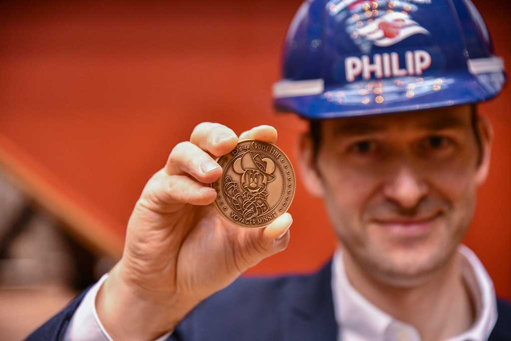 Philip Gennotte, portfolio project management executive, Walt Disney Imagineering Germany, took part in the keel laying ceremony for the Disney Treasure at Meyer Werft shipyard in Papenburg, Germany. During the ceremony, a time-honored maritime tradition, a newly minted coin was placed under the keel of the ship for good fortune. The commemorative coin used in the ceremony featured an etching of Captain Minnie Mouse donning a new look that embodies ship’s adventure motif. (Robert Fiebak, photographer)