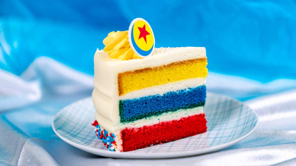 Pixar Fest Cake at Plaza Inn will be at Disneyland Park in Anaheim, Calif. – layers of yellow, blue and red vanilla sponge cake with cream cheese frosting and chocolate Pixar Ball decoration. Available beginning April 26, 2024. (David Nguyen/Disneyland Resort)