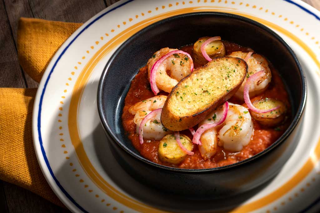 At Plaza de Coco, an array of artful dishes will transport guests to the picturesque town depicted in the Pixar Animation Studios film, “Coco.” The Abuelita Elena Shrimp Diabla will feature chili-chipotle sauce, cilantro, pickled red onion and toasted birote. (Kent Phillips, Photographer)