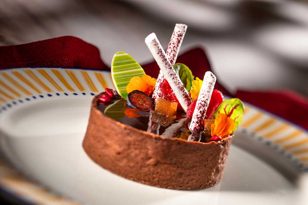 At Plaza de Coco, an array of artful dishes will transport guests to the picturesque town depicted in the Pixar Animation Studios film, “Coco.” The Mexican Chocolate Tart will include spiced chocolate crème, caramel pecan nuts and chocolate glaze. (Kent Phillips, Photographer)